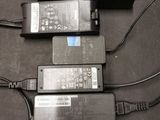 three laptops and a charger are sitting on a table