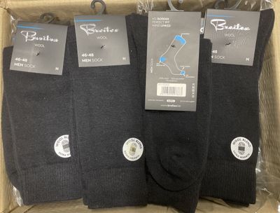three pairs of men ' s black socks in a cardboard box