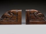 a pair of carved wood bookends depicting a man and a woman