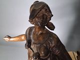 bronze statue of a woman sitting on a horse with a dog