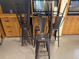 several chairs and a table in a room with a television in the background