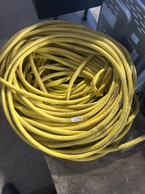 un tuyau jaune posé sur un coffret métallique