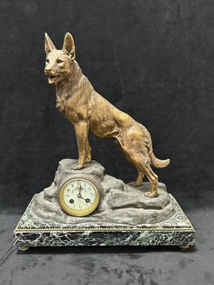statue d'un chien assis sur un rocher, avec une horloge, sur fond noir