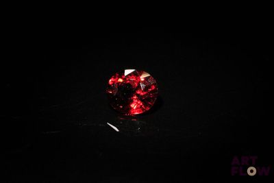 gros plan d'un diamant rouge sur une surface noire