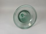 a glass vase with a green top sitting on a white surface