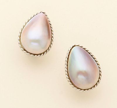 two pairs of pearl earrings on a beige background