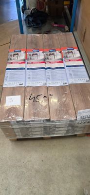 une palette remplie de cartons posée à même le sol dans un entrepôt