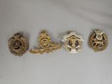 four badges of various sizes and shapes on a white surface