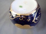 a blue vase with gold designs on it sitting on a table