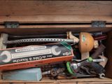 a wooden box filled with tools on a black surface