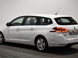 the rear end of a white car parked in a white room