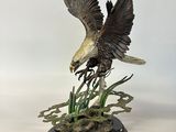 une image représentant une statue d'aigle tenant un poisson dans une serre