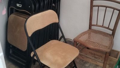 a stack of chairs next to a stack of suitcases