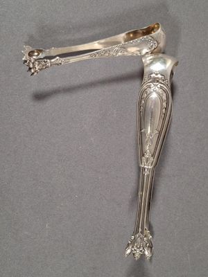 a silver spoon with a handle on a gray surface