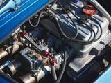 a blue car with an engine in the trunk