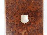 a small wooden box with a white shield on top of it
