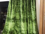 a green curtain hanging on the wall next to a wooden cabinet