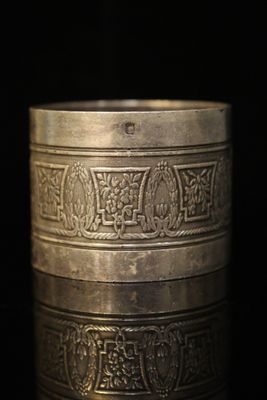 gros plan d'une bague en argent sur une surface noire