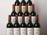 des bouteilles de vin rouge sont posées sur une table en bois devant un mur blanc