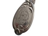 a silver spoon with a design on it on a white background