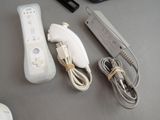 a wii remote, a controller, and a charger on a table