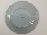 a blue plate on a white table with a blue dot