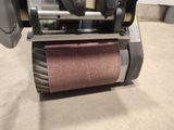 a close up of a machine with a roll of sand on it