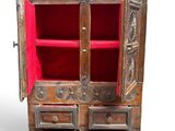 an image of a wooden cabinet with drawers and a red door