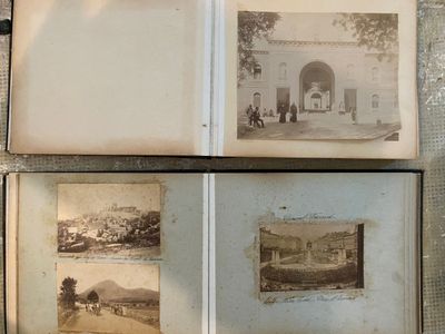 several old photos of people and buildings are displayed in an open book