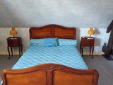 a bed that has a blue comforter on top of it