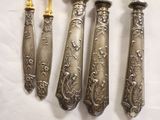four silverware pieces are arranged on a white table cloth