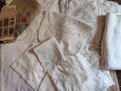beaucoup de linge de lit blanc sur un lit, à côté d'un panier