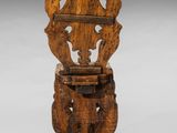 an old wooden chair with a carved back and seat