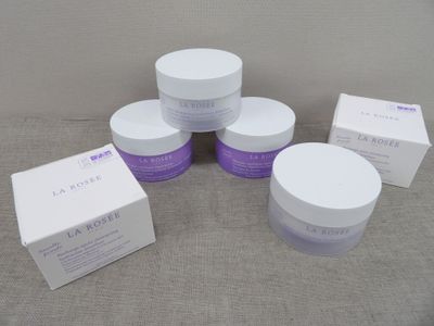 quatre pots de produits de soin posés sur une table