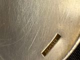 a close up of a silver plate with a gold label on it