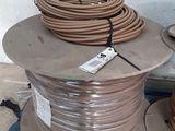 a coil of wire on the ground next to a box of wires
