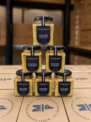 a stack of six jars of mustard sitting on top of a cardboard box
