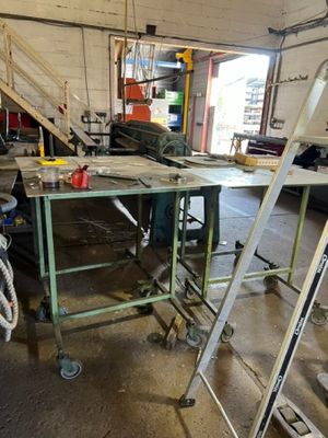 a man that is standing next to a table in a garage