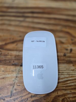 a white apple mouse sitting on top of a wooden table