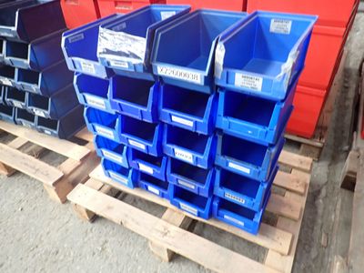 many blue bins stacked on a pallet in a warehouse