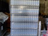 une pile de bacs en plastique posée sur une palette dans un entrepôt