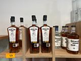 Plusieurs bouteilles d'alcool sont posées sur une étagère dans un magasin.