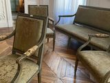 chairs and a couch in a room with a painting on the wall