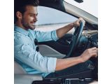 a man that is sitting in the driver ' s seat of a car