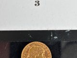 a close up of a gold coin on a black surface