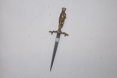 a close up of a knife on a white surface with a bird on it