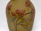 a yellow vase with pink flowers on it on a white background