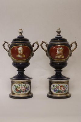 pair of antique vases with painted faces on them on a white background