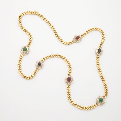 un collier en or orné de pierres multicolores sur fond blanc