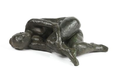 sculpture en bronze représentant un homme allongé sur le dos sur une surface blanche